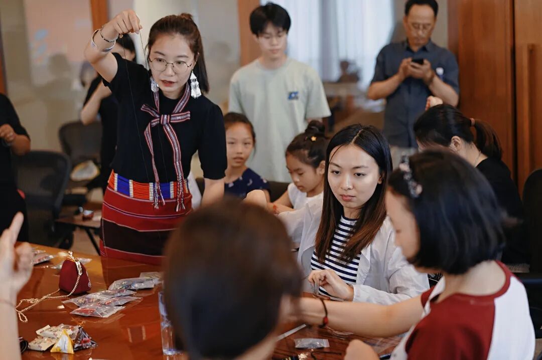 在廖静文的佤族织锦工作室里,一群来自普洱学院的学生正围着她,目不转睛地观察她手中的织锦纹样。陈龙汝男摄 2025年6月9日.jpg